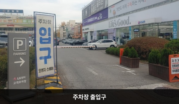 북인천서비스센터의 건물 왼쪽에 주차장 출입구가 있습니다. 출입구 오른쪽에 'P'라고 적힌 입간판이 있으며, 진입 시 인도를 경유하기 때문에 주의가 필요합니다.
