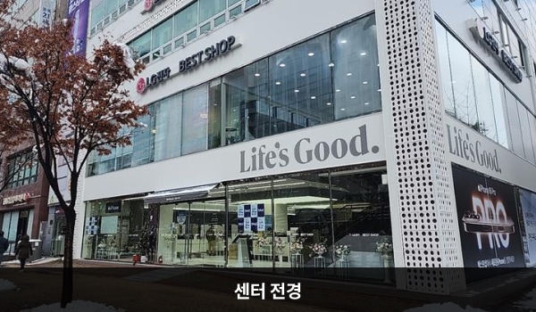 부천서비스센터의 흰색 건물 1층부터 3층까지 유리가 크고 많습니다. 3층 간판에는 'LG전자 서비스센터 ' , 2층 간판에는 'LG전자 BEST SHOP '이라고 적혀 있습니다.