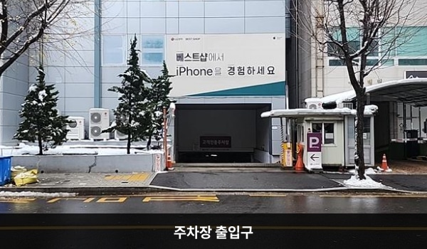 부천서비스센터의 건물 뒤쪽에 지하 주차장 출입구가 있습니다. 출입구 오른쪽에 'P'라는 글자가 적힌 입간판이 있으며, 정면에 '고객전용주차장' 문구가 붙어 있습니다.