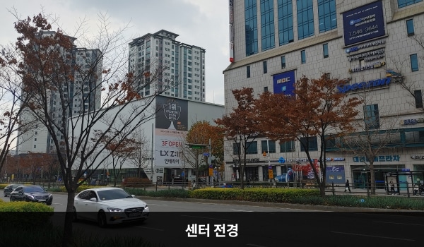남수원서비스센터의 서비스센터 건물은 높고 흰색이며 창문이 보이지 않습니다. 건물에 'LG전자'라고 쓰여 있습니다.