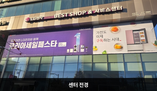 서대전서비스센터의 서비스센터 건물은 작은 유리창이 많습니다. 2층 간판에 흰색 글씨, 분홍색 바탕으로 'LG전자 BEST SHOP & 서비스센터'라고 쓰여 있습니다.