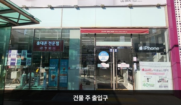 사하서비스센터의 건물 정면 우측에 주 출입구가 있습니다. 유리문으로 되어 있으며, 양쪽 문 안쪽에 긴 손잡이가 있습니다.