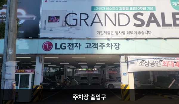 사하서비스센터의 건물 1층이 주차장입니다. 주차장 출입구는 건물 정면에 있습니다. 출입구 위쪽에 'LG전자 고객주차장'이라고 적혀 있습니다.