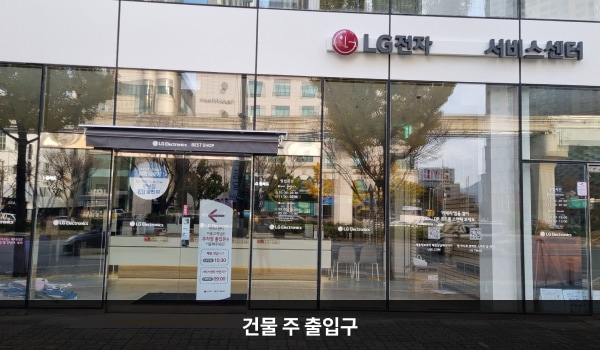 동대구서비스센터의 건물 1층 'LG전자 서비스센터' 간판 왼쪽 아래에 건물 주 출입구가 있습니다. 출입문은 자동문이며, 문 위에 검은색 차양막이 있습니다.