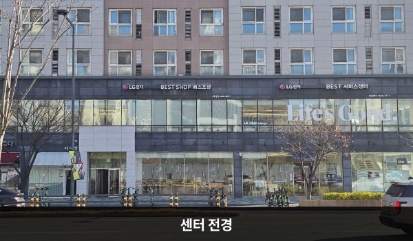 세종서비스센터의 건물 2층 검은 간판에 'LG전자 BEST SHOP 베스트샵', 'LG전자 BEST 서비스센터'라고 적혀 있습니다. 건물 1층과 2층에는 유리가 크고 많습니다.