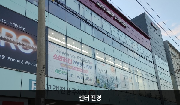 미사본점서비스센터의 건물 꼭대기 붉은 간판에 'LG전자 BEST SHOP & 서비스센터'라고 적혀 있습니다. 건물 1층에 주차장이 있으며, 전체에 유리창이 크고 많습니다.