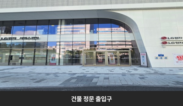 둔산서비스센터의 건물 주 출입구는 유리문으로 되어 있으며, 두 개의 큰 문이 있습니다. 문 가운데에 긴 손잡이가 있습니다.