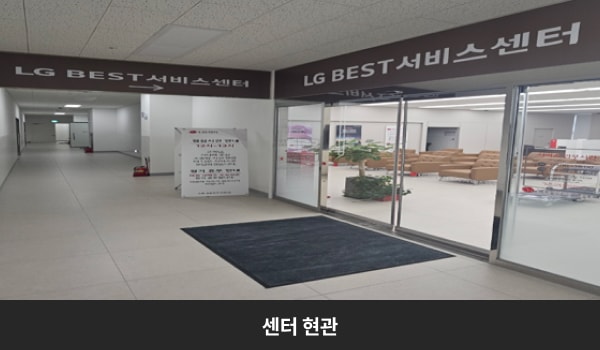 둔산서비스센터의 센터 현관 위쪽에 'LG BEST 서비스센터'라는 문구가 적혀 있으며, 그 아래에 유리로 된 자동문이 있습니다. 문을 열고 들어가면 왼쪽에 고객 대기실이 있습니다.