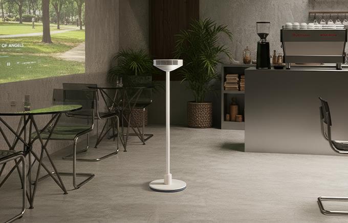 카페 같은 실내 공간 한가운데 LG 무드메이트가 놓여 있고, 왼쪽 벽면에는 공원 풍경 영상이 투사되어 있습니다. 오른쪽에는 커피머신과 선반이 배치되어 있습니다.