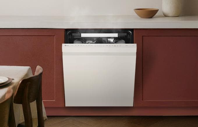 주방 하부장에 빌트인으로 설치된 식기세척기가 문을 살짝 연 채 내부에서 김이 나는 모습이다