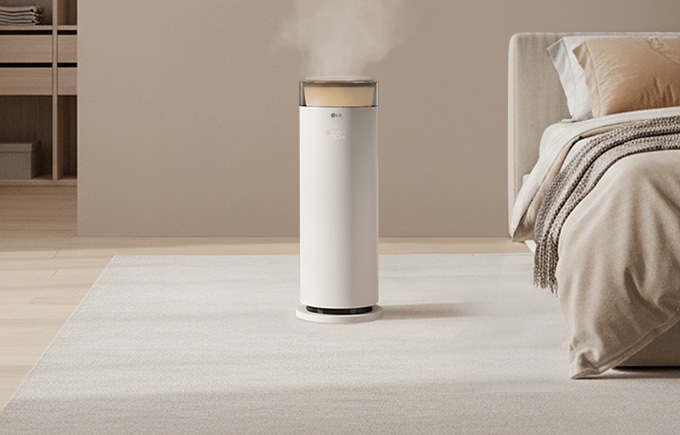 따스한 배경의 안방 중앙에는 하이드로에센셜이 수증기를 내뿜으며 표현되고 있으며 우측에는 침대가 있습니다.