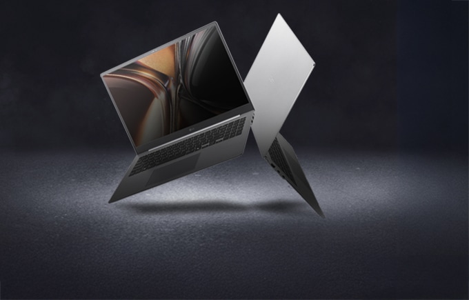 세련된 그레이 톤의 바닥 위에 실버 컬러의 LG 그램 노트북 두 대가 서로 등지고 펼쳐져 허공에 살짝 떠있으며, 하나는 화면의 선명한 화질을 보여주고 앞의 노트북은 등지고 있는 이미지