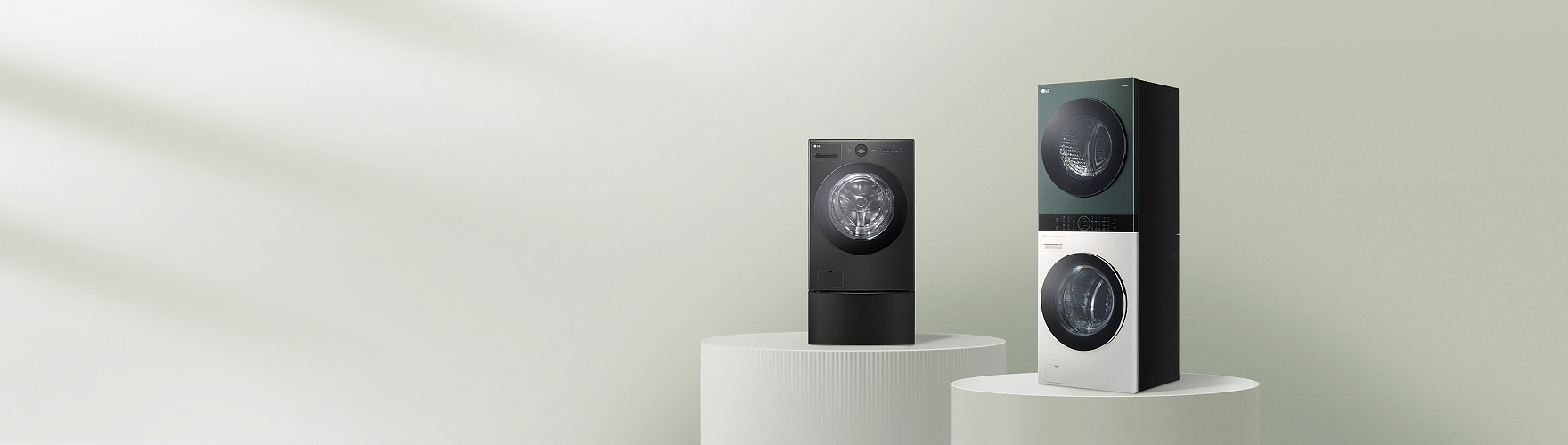LG 트롬 세탁기 블랙 모델과 LG 트롬 워시타워가 원형 받침대 위에 전시된 제품 이미지