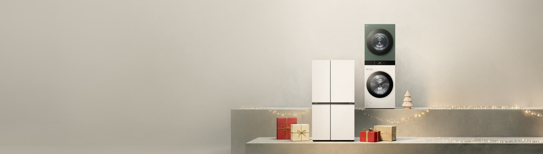 밝은 베이지 톤의 공간에 선반 위에 LG전자 냉장고, 트롬 워시타워가 배치되어 있고, 주변에 빨간색과 골드색 리본이 달린 선물 상자들과 나무 장식, 조명 가랜드가 놓여 있다.