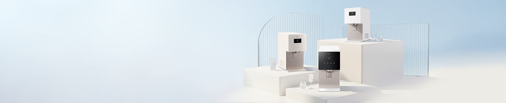 화이트 톤의 미니멀한 공간에서 유리 패널과 단차 구조 위에 LG 퓨리케어 얼음 정수기 3종이 배치되어 있으며, 옆에는 물이 담긴 유리컵이 놓인 깔끔하고 고급스러운 연출