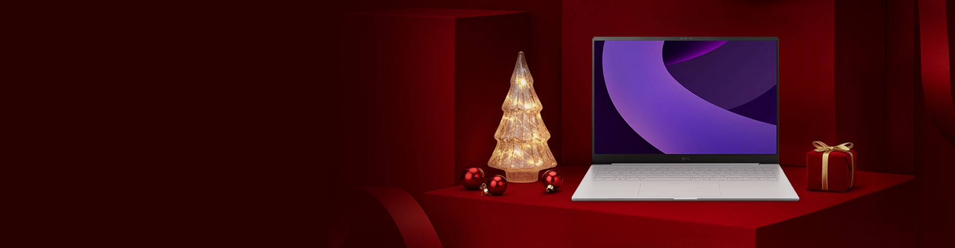 레드 기프트 박스 배경 위에 LG 그램 노트북이 놓여 있고, 좌측에는 조명 트리, 우측에는 리본 선물이 배치된 연말 분위기 구성.