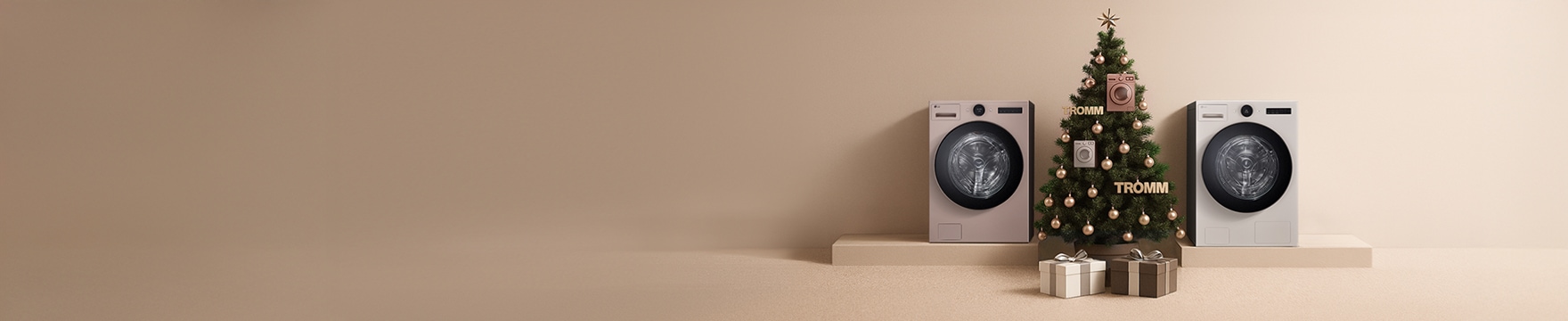 건조기 두대 사이로 크리스마스 트리가 있고 선물 상자들이 놓여있는 모습