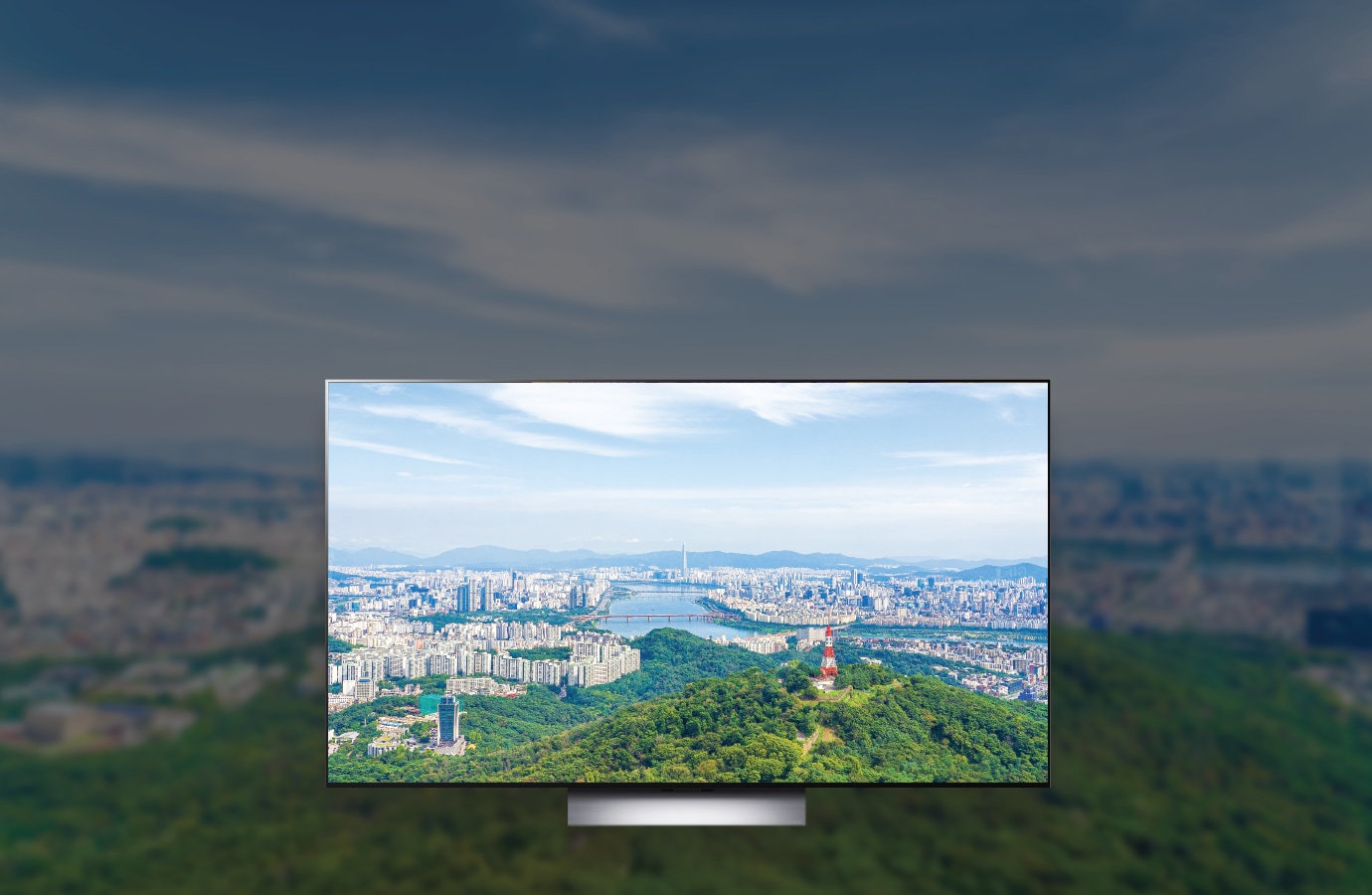 중앙에 tv 프레임이 배치되어 있고 파란 하늘과 구름이 보이고 멀리는 한강이 보이고 남산이 보입니다