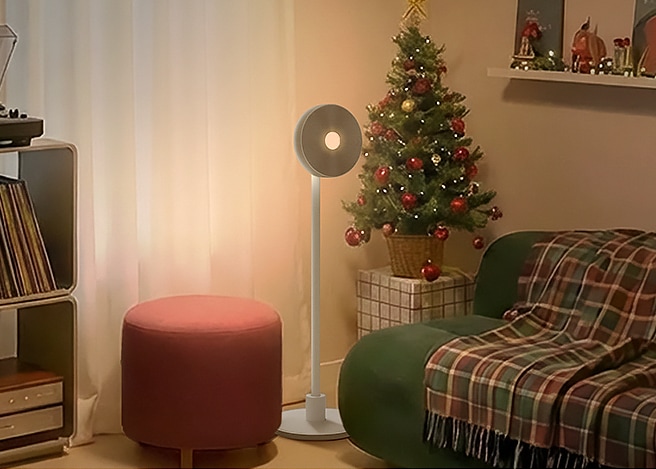 레드 기프트 박스 배경 위에 LG 그램 노트북이 놓여 있고, 좌측에는 조명 트리, 우측에는 리본이 묶인 선물이 배치된 연말 분위기의 구성.