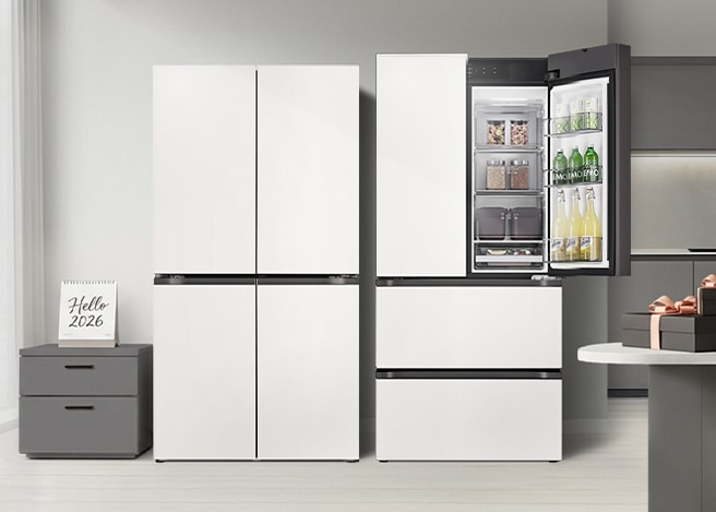 좌우로는 달력과 선물이 아일랜드 식탁위에 있고, 중앙에는 깔끔한 화이트 컬러의 LG 디오스 오브제컬렉션 냉장고와 한쪽 문이 열려 내부 수납 공간이 보이는 김치냉장고가 있는 이미지 