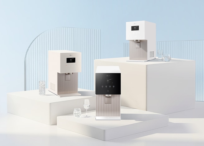 화이트 톤의 미니멀한 공간에서 유리 패널과 단차 구조 위에 LG 퓨리케어 얼음 정수기 3종이 배치되어 있으며, 옆에는 물이 담긴 유리컵이 놓인 깔끔하고 고급스러운 연출