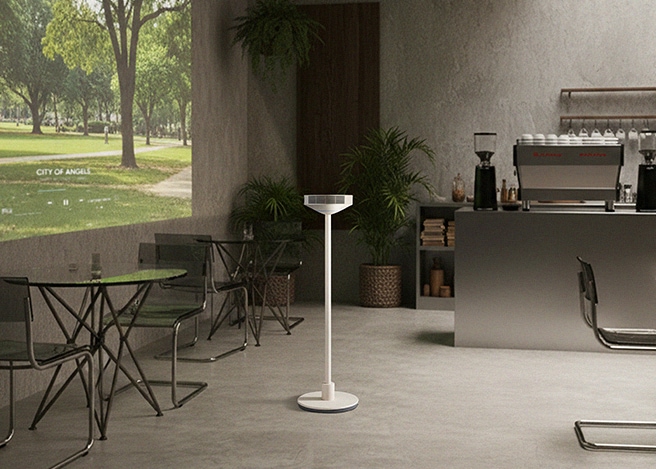 “카페 같은 실내 공간 한가운데 LG 무드메이트가 놓여 있고, 왼쪽 벽면에는 공원 풍경 영상이 투사되어 있다. 오른쪽에는 커피머신과 선반이 배치되어 있습니다