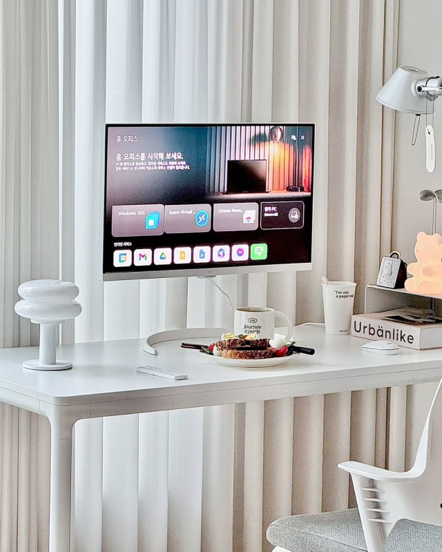 책상 위에 놓인 LG 스마트 모니터로 홈 오피스 환경을 구성한 모습. 모니터 화면에는 원격 PC 접속 및 다양한 업무용 앱이 실행되고 있다.