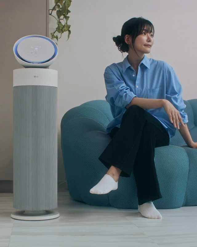 에어로부스터 제품 옆 청록색 소파에 앉아 오른쪽을 쳐다보고 있는 여성에어로부스터 제품 옆 청록색 소파에 앉아 오른쪽을 쳐다보고 있는 여성
