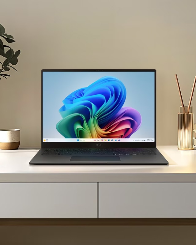 책상 위에 LG 그램 노트북이 놓여 있으며, 화면에는 다채로운 색상의 추상적인 그래픽이 표시된 모습.